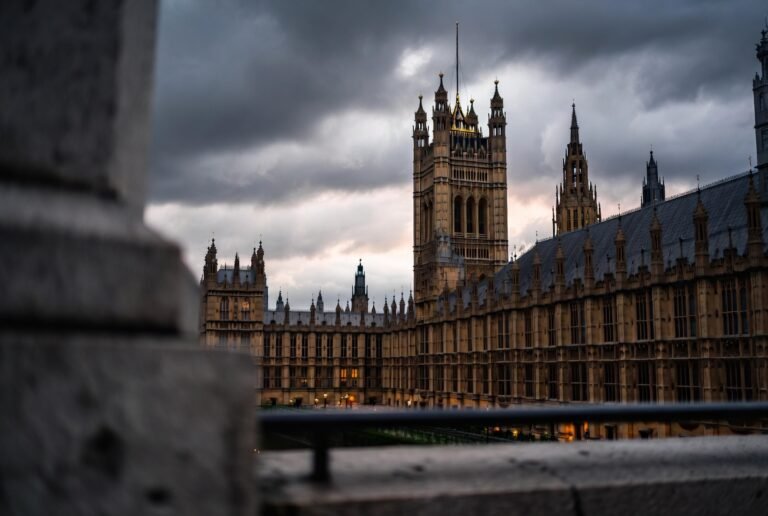 UK Parliament at dusk with storm clouds — UK political crisis 2026