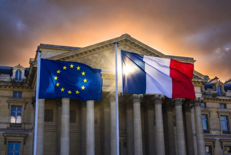 French and European Union flags flying together outside a government building in Paris representing France's EU leadership strategy in 2026