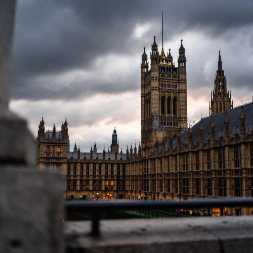 UK Parliament at dusk with storm clouds — UK political crisis 2026