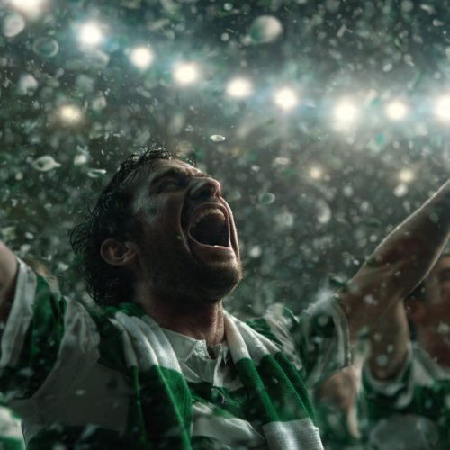 Ultra-realistic cinematic football stadium scene showing Celtic players celebrating league title win under dramatic lights, green and white confetti falling, emotional crowd atmosphere, editorial sports photography style, 16:9 aspect ratio banner style image banner style