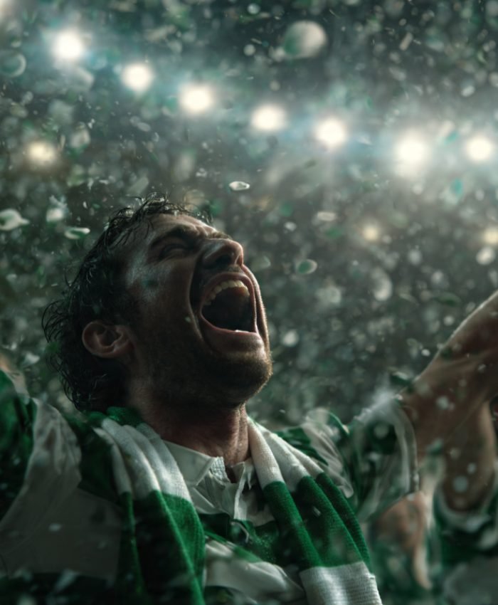 Ultra-realistic cinematic football stadium scene showing Celtic players celebrating league title win under dramatic lights, green and white confetti falling, emotional crowd atmosphere, editorial sports photography style, 16:9 aspect ratio banner style image banner style
