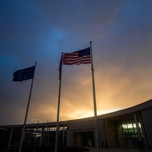 US and EU flags at an international summit building representing transatlantic alliance tensions in 2026