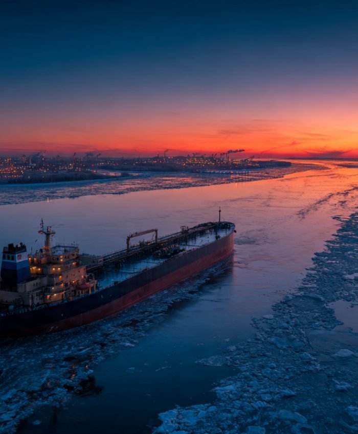 A Russian oil tanker navigating Arctic waters at dusk, representing Russia oil revenue 2026 and global energy exports.